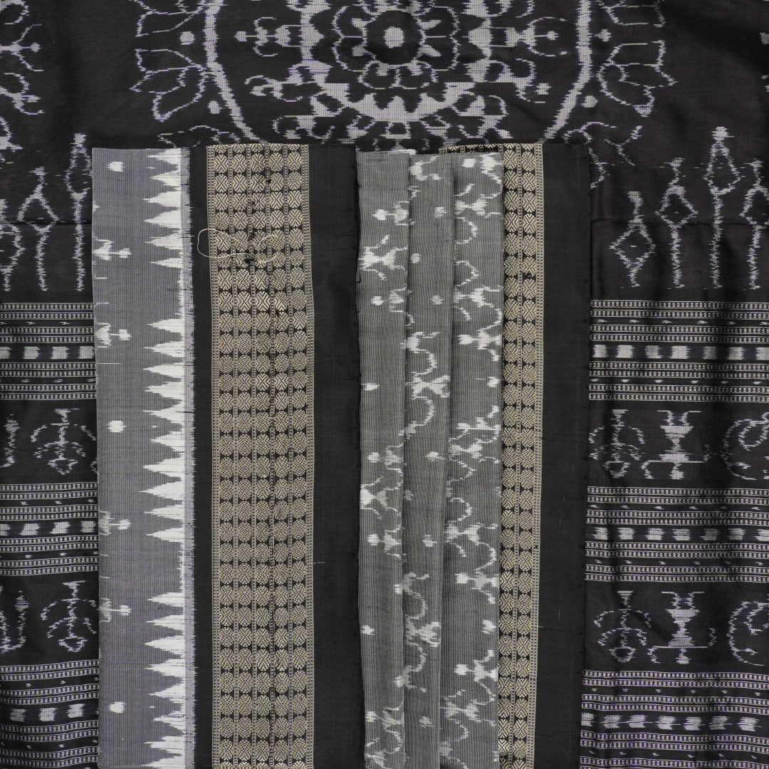 Close-up of grey & black Sambalpuri silk saree fabric, highlighting its rich texture and weave.