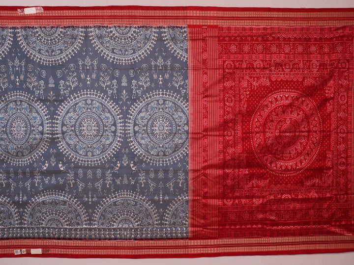 Close-up of grey and red Sambalpuri silk saree fabric showing intricate woven motif texture.