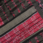 Detailed close-up of the maroon and black Sambalpuri silk saree's luxurious fabric texture and weave.