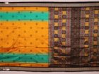 Close-up of yellow silk Bomkai saree fabric with black butta pattern