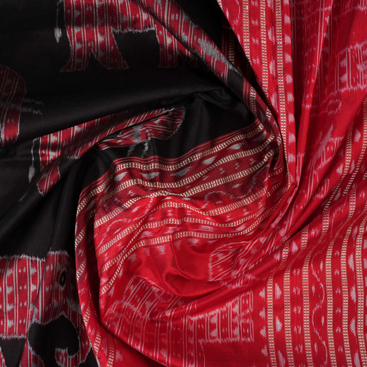 Close-up showing the luxurious texture and fine weave of the black Sambalpuri silk fabric.