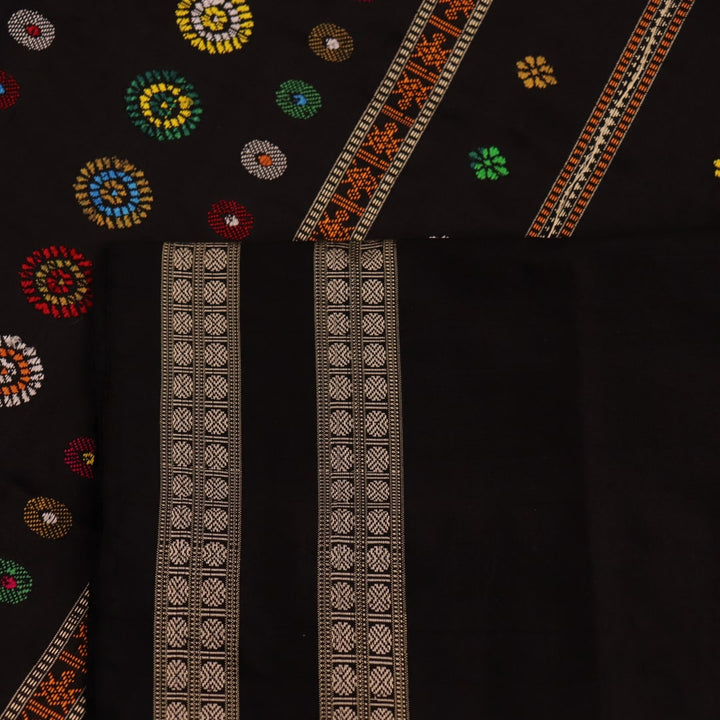 Close-up view of the soft and lustrous silk fabric texture of a Dolabedi red and black handloom saree with a butta pattern.