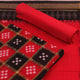 Detail of the black Sambalpuri cotton Pasapalli dress material's blouse piece with red accents.