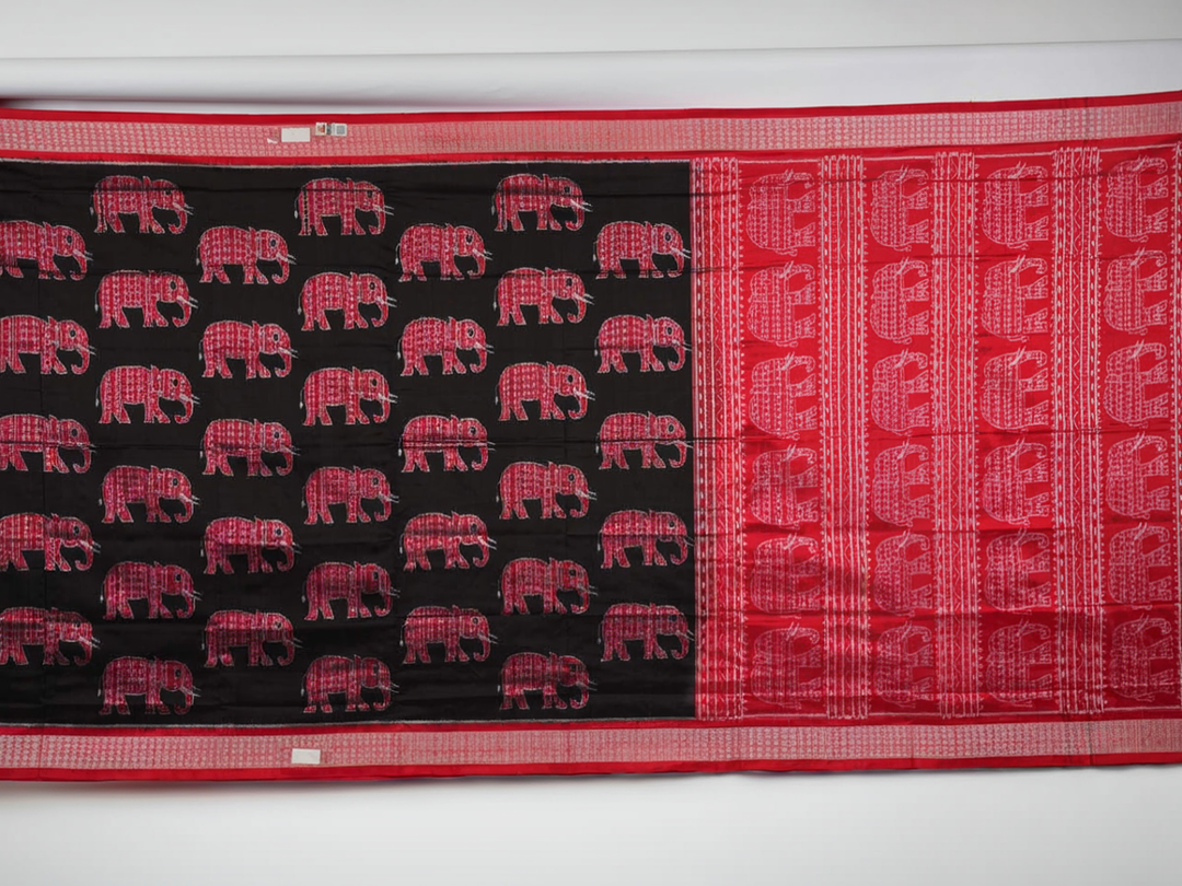 Close-up showing the luxurious texture and fine weave of the black Sambalpuri silk fabric.