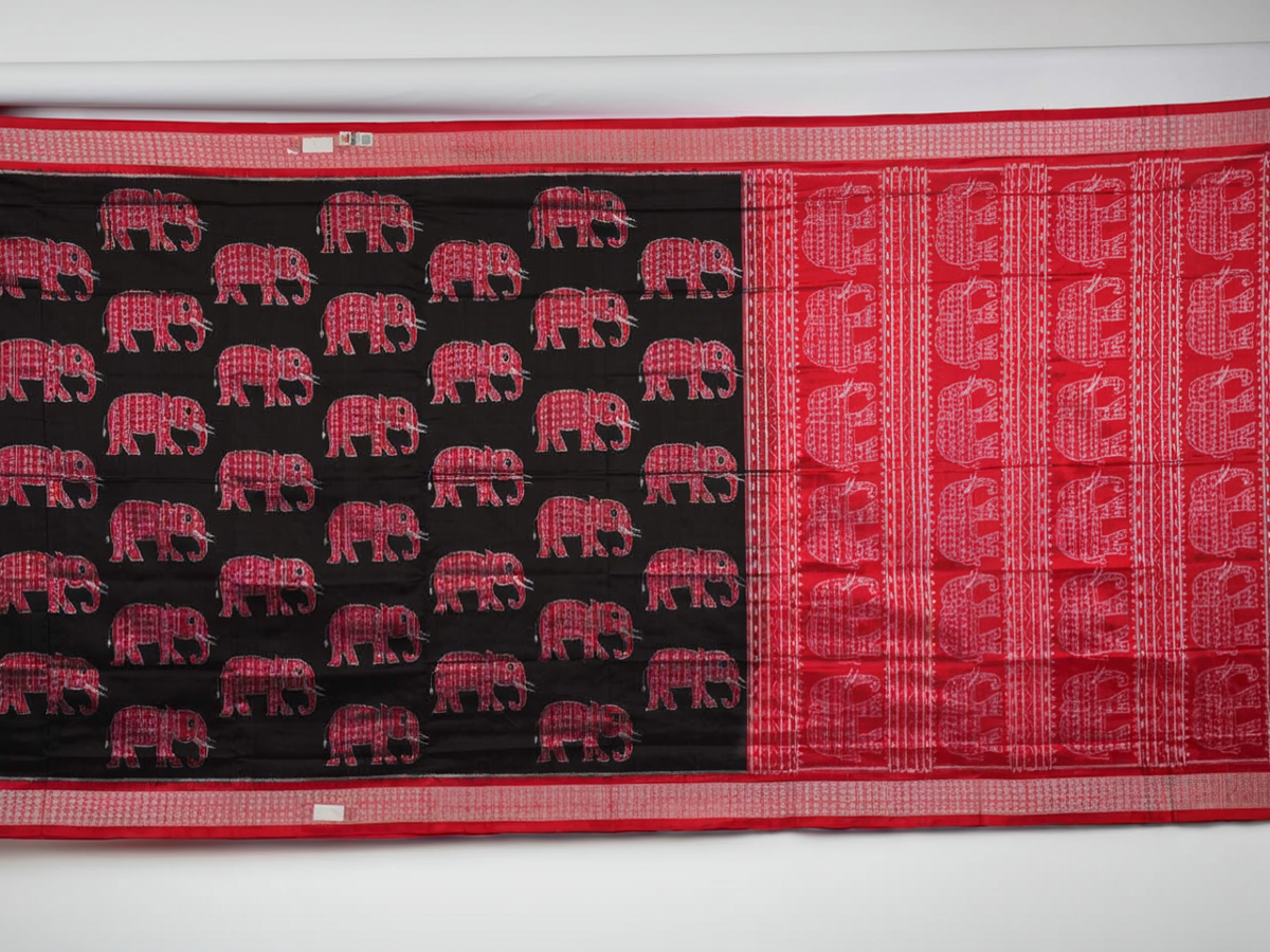 Close-up showing the luxurious texture and fine weave of the black Sambalpuri silk fabric.