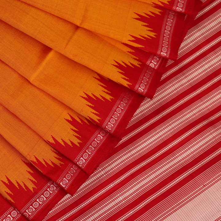 Close-up view of the smooth and lustrous silk fabric texture in a plain yellow Berhampuri saree.