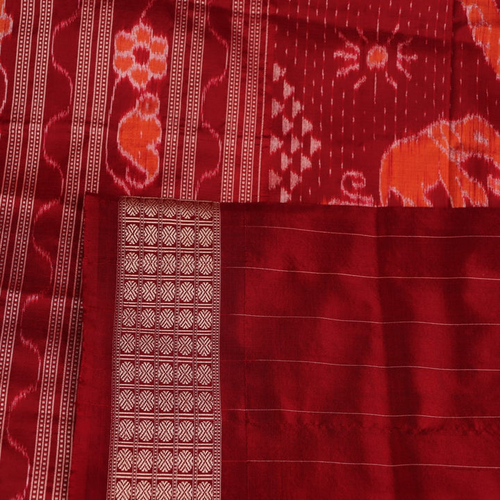 Close-up of multicolored Sambalpuri silk saree fabric texture showing intricate weave and maroon accents.