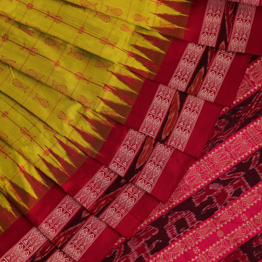 Close-up view of the soft silk fabric texture of a green and magenta Sambalpuri saree with intricate butta patterns