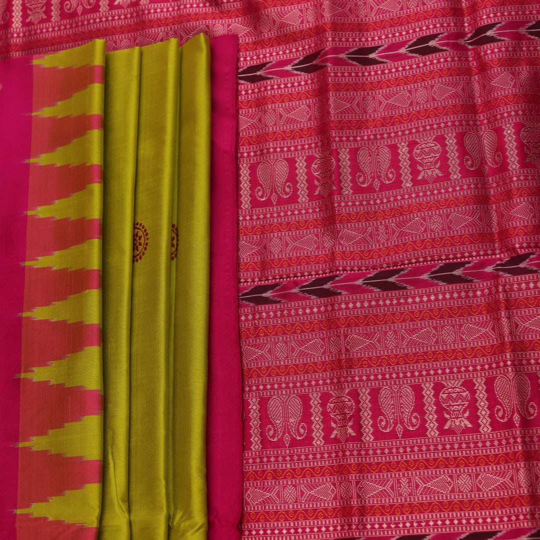 Close-up of green and magenta Bomkai silk saree fabric texture, highlighting intricate weave and butta pattern.