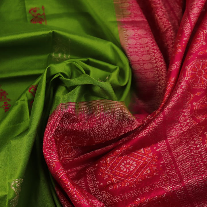 Textured close-up of green Bomkai silk saree fabric, revealing intricate weave and magenta butta pattern.