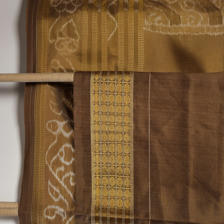 Close-up revealing the delicate, lustrous texture of the black silk tissue saree fabric with subtle sheen.