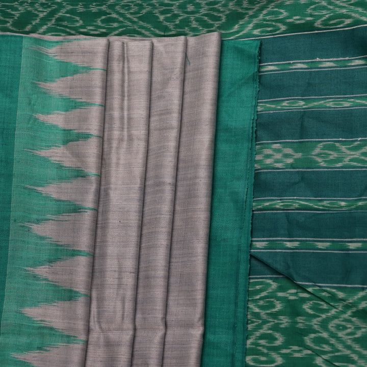 Close-up of textured grey and green Tussar silk fabric used in a plain pattern saree