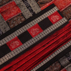 Detailed texture of handwoven Bomkai silk saree fabric in maroon and black with butta pattern.