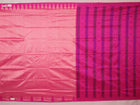 Close-up of plain peach and pink Sambalpuri silk saree fabric texture.
