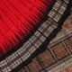 Detailed close-up of the red and black Bomkai silk saree fabric texture, featuring a butta pattern.