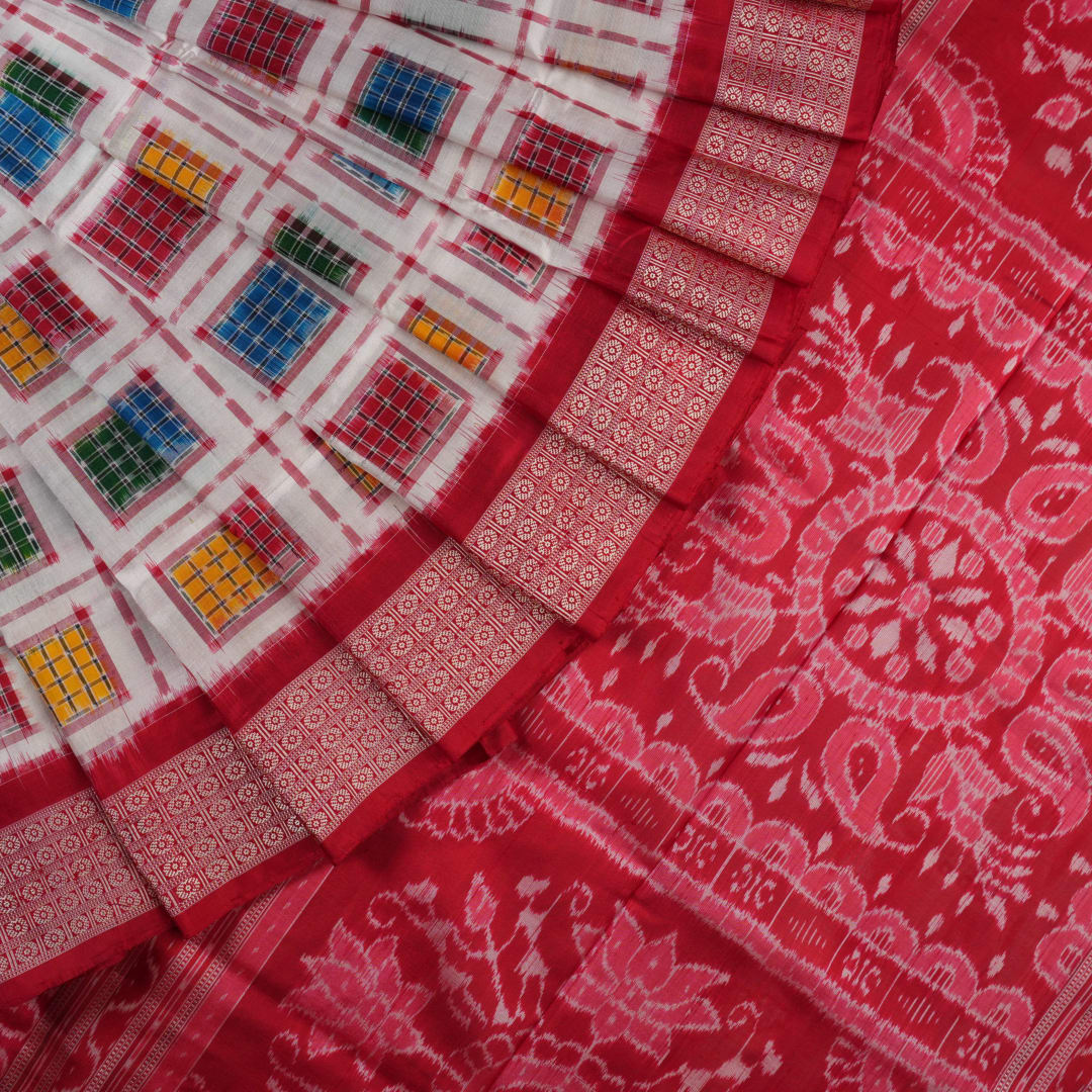 Close-up of the luxurious white Sambalpuri silk saree fabric, highlighting its rich texture and weave.
