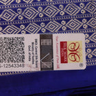 Close-up of green and blue Sambalpuri silk saree fabric showing intricate handloom weave and motif details.