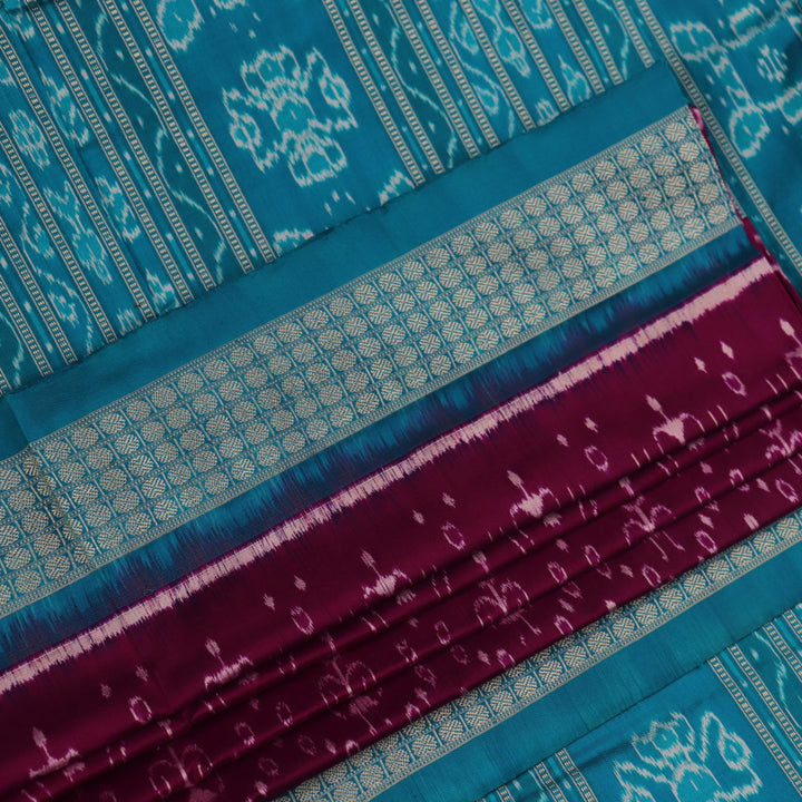 Close-up showcasing the purple and blue silk fabric texture of the Sambalpuri saree with intricate motifs.