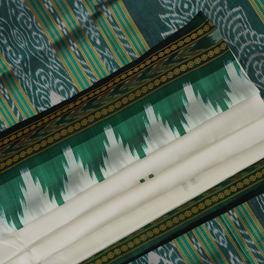 Model wearing a white Khandua silk saree with green butta and border, showcasing a graceful drape.