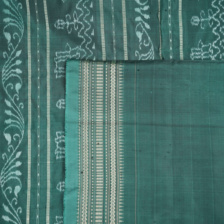 Close-up of green Sambalpuri silk fabric, showing its luxurious texture and fine handloom weave.