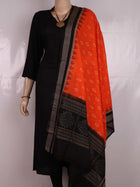 Full body view of a folded Sambalpuri cotton dupatta in orange with bold black motifs.