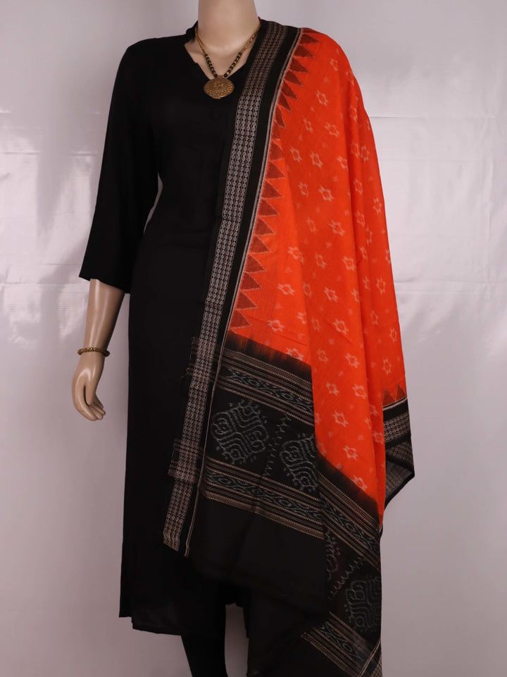 Full body view of a folded Sambalpuri cotton dupatta in orange with bold black motifs.