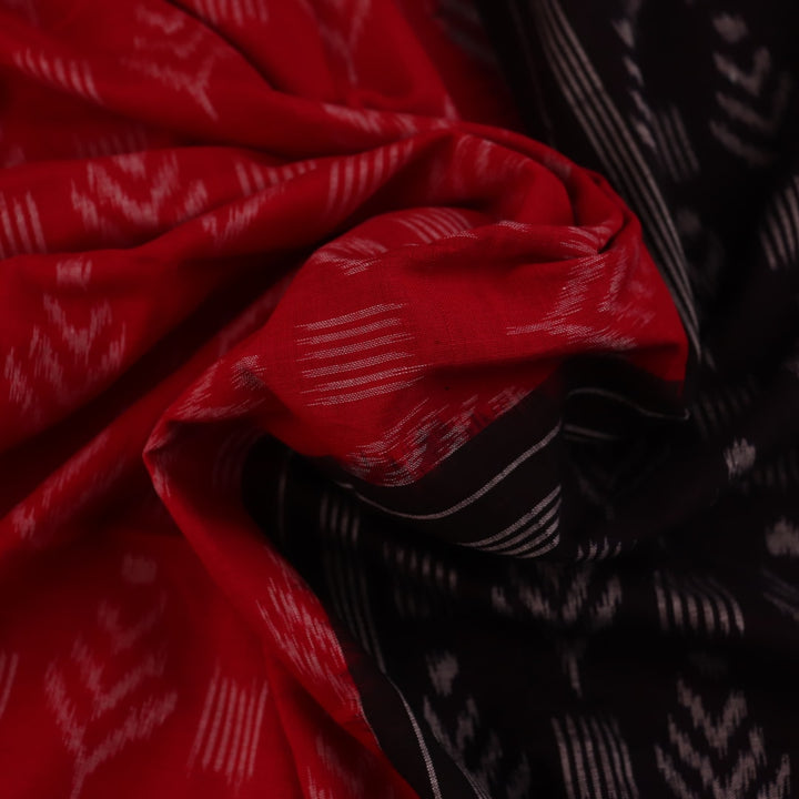 Red and black Sambalpuri cotton saree with motifs, elegantly draped to showcase its style and design.