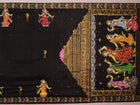 Close-up of black silk Patachitra saree fabric texture showing hand-painted details.