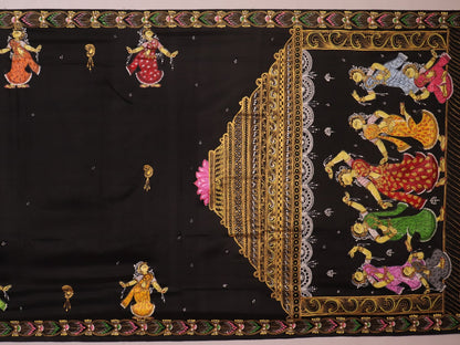 Close-up of black silk Patachitra saree fabric texture showing hand-painted details.