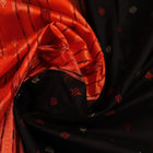 Close-up view of black silk Bomkai saree fabric showcasing its intricate butta pattern.