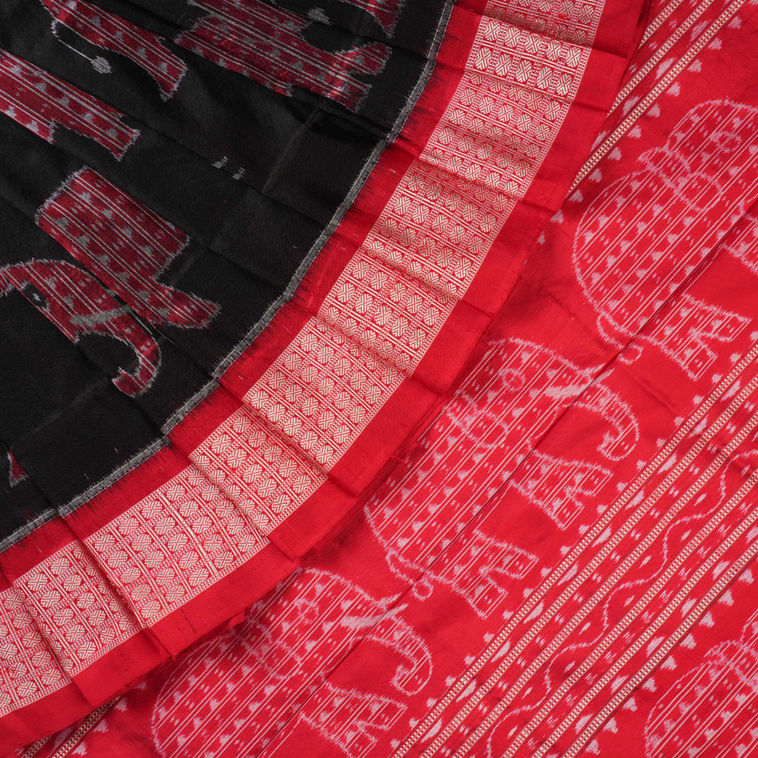Close-up showing the luxurious texture and fine weave of the black Sambalpuri silk fabric.