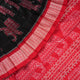 Close-up showing the luxurious texture and fine weave of the black Sambalpuri silk fabric.