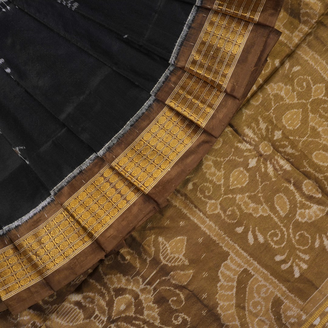 Close-up revealing the delicate, lustrous texture of the black silk tissue saree fabric with subtle sheen.