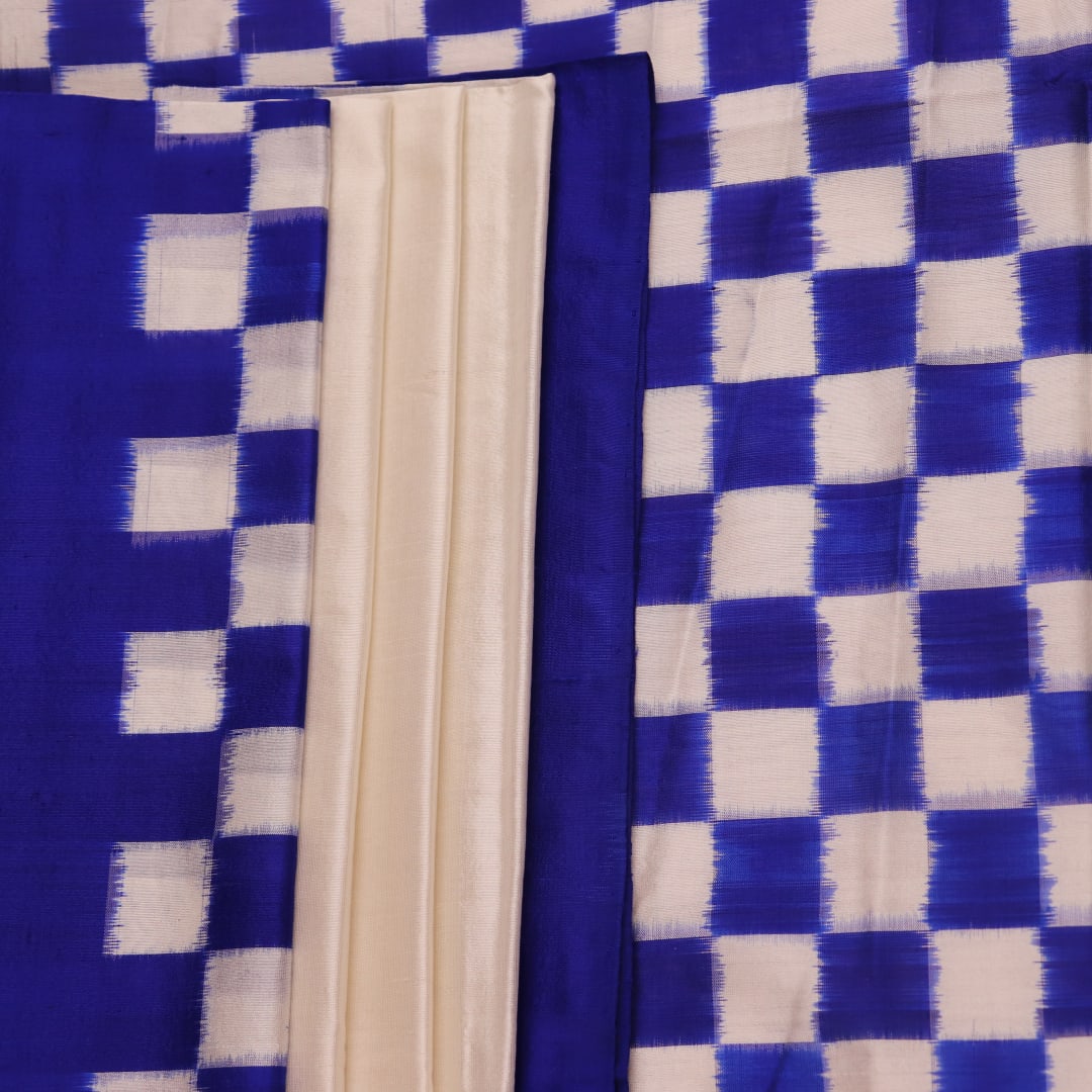 Close-up of the intricate Pasapalli pattern woven on a luxurious white silk Sambalpuri saree with blue accents.