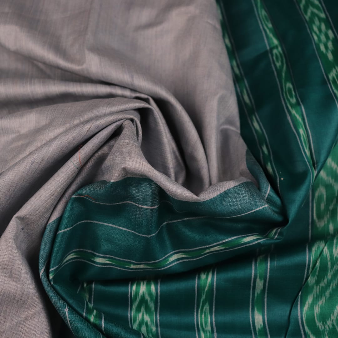 Close-up of textured grey and green Tussar silk fabric used in a plain pattern saree