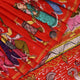 Close-up of red Patachitra silk saree fabric showing hand-painted texture.