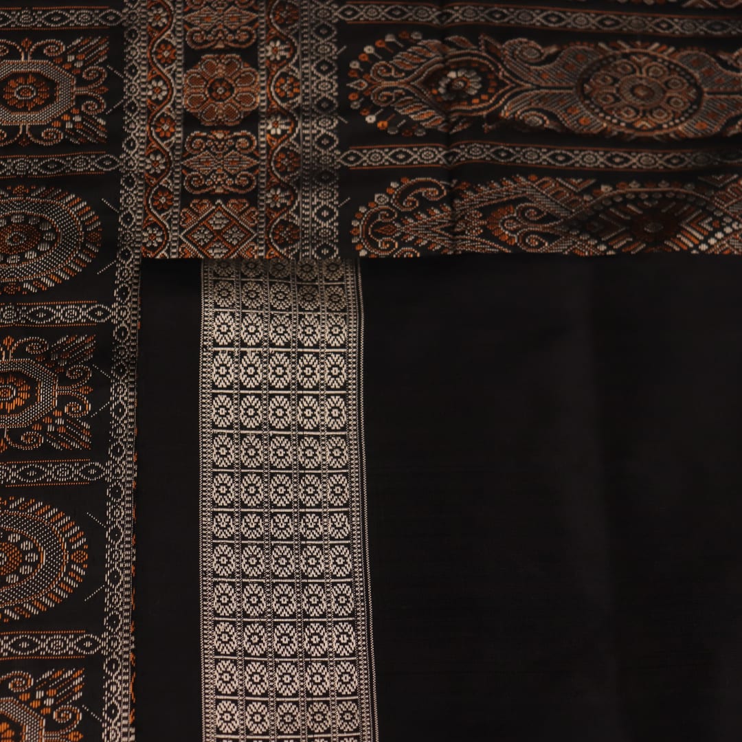 Close-up of the intricate woven texture of blue and black Bomkai silk saree with butta.