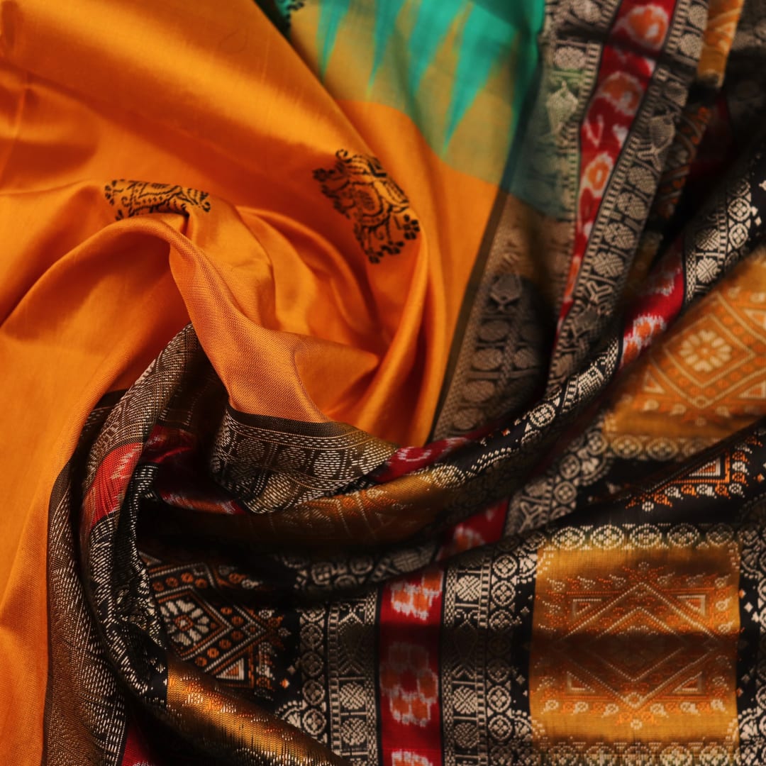 Close-up of yellow silk Bomkai saree fabric with black butta pattern