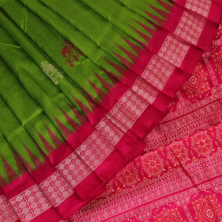 Textured close-up of green Bomkai silk saree fabric, revealing intricate weave and magenta butta pattern.