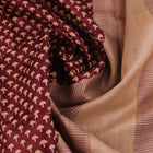 Close-up of maroon Tussar silk saree fabric, showing natural slub texture and printed pattern.