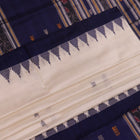 Close-up of white and blue Sambalpuri Silk Saree fabric texture, highlighting butta pattern.