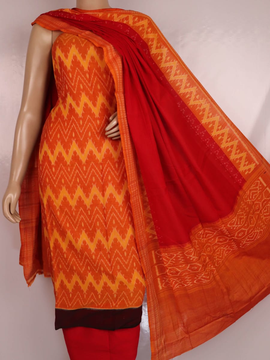 Close-up detail showcasing the traditional motifs in orange and red on cotton Sambalpuri dress material.