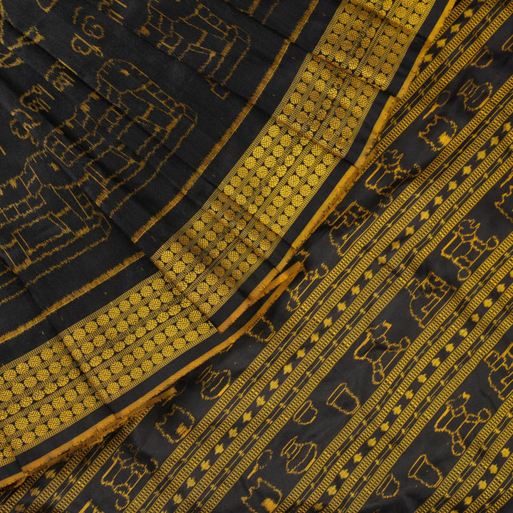 Close-up of the black Sambalpuri silk saree fabric, revealing its rich texture and the intricate weave of the motifs.