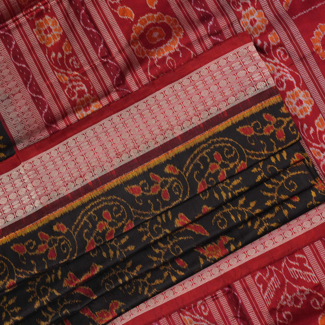 Close-up of Sambalpuri silk fabric texture, highlighting fine handloom weave in black and maroon.