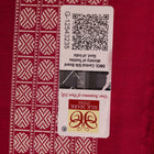 Textured close-up of green Bomkai silk saree fabric, revealing intricate weave and magenta butta pattern.