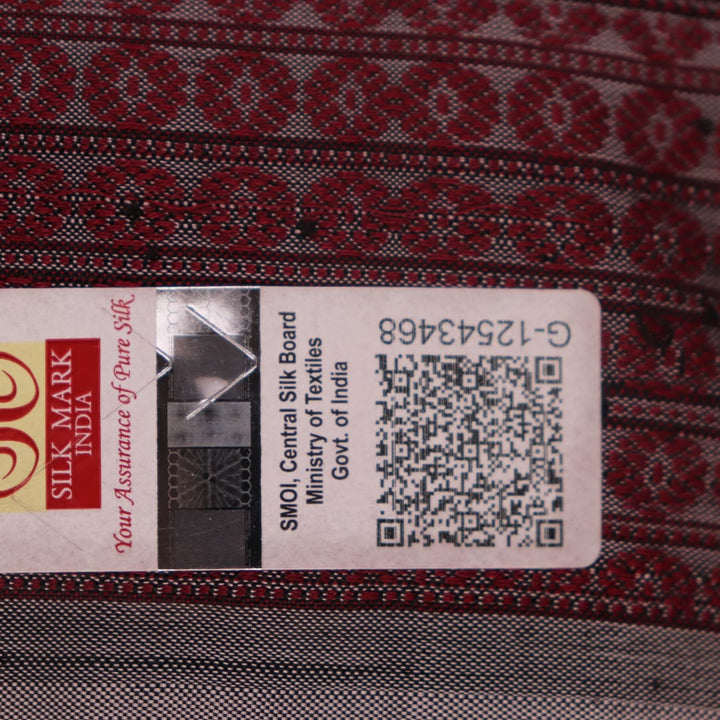 Close-up of a multicolored silk Sambalpuri saree fabric showing the intricate handloom texture and motifs.