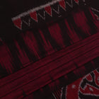 Plain maroon and black Sambalpuri cotton saree, elegantly draped.