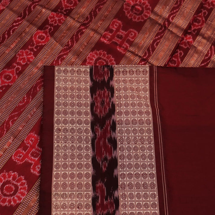 An approximately 150 cm wide handloom black silk Sambalpuri Saree with maroon motifs, captured in a close-up to depict its rich fabric texture.