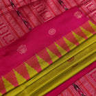 Close-up of green and magenta Bomkai silk saree fabric texture, highlighting intricate weave and butta pattern.