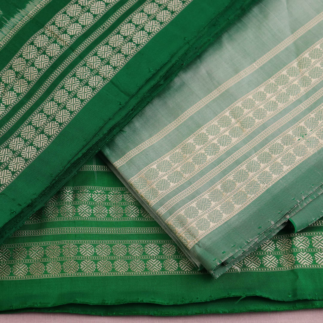 Close-up of the green Sambalpuri silk dress material blouse piece, detailed with traditional motifs.